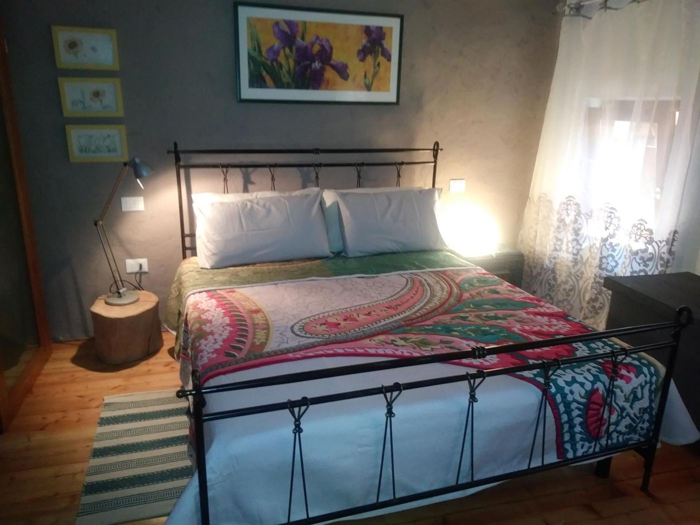 Camera con letto in ferro battuto e coperta colorata